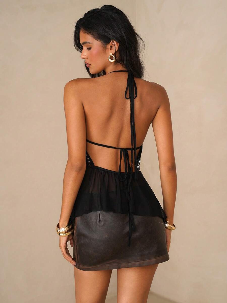 Women's black studded halter cami top with spaghetti straps, tie-back backless design, and asymmetrical hem