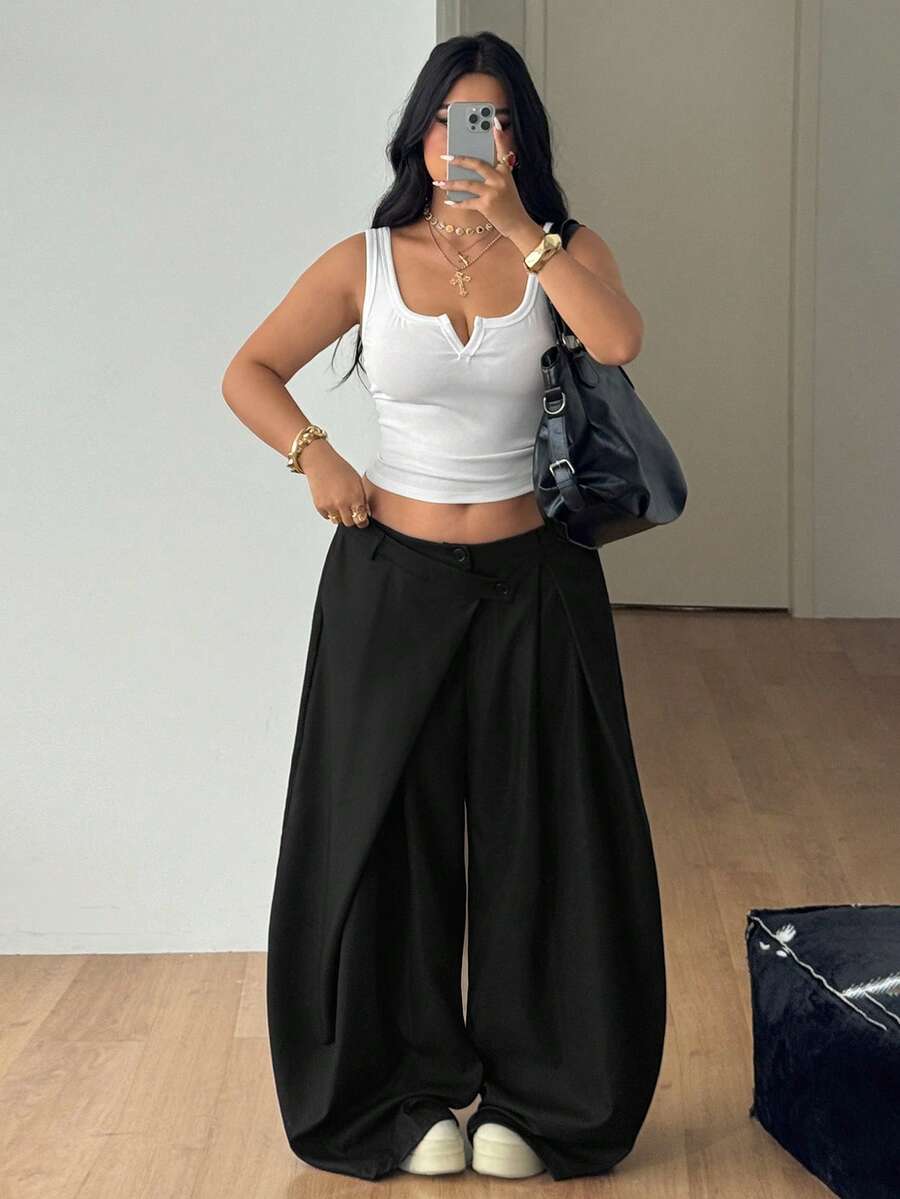 Front view of women's loose curved banana pants featuring a mid waist, side pockets, and asymmetrical plicated hem.