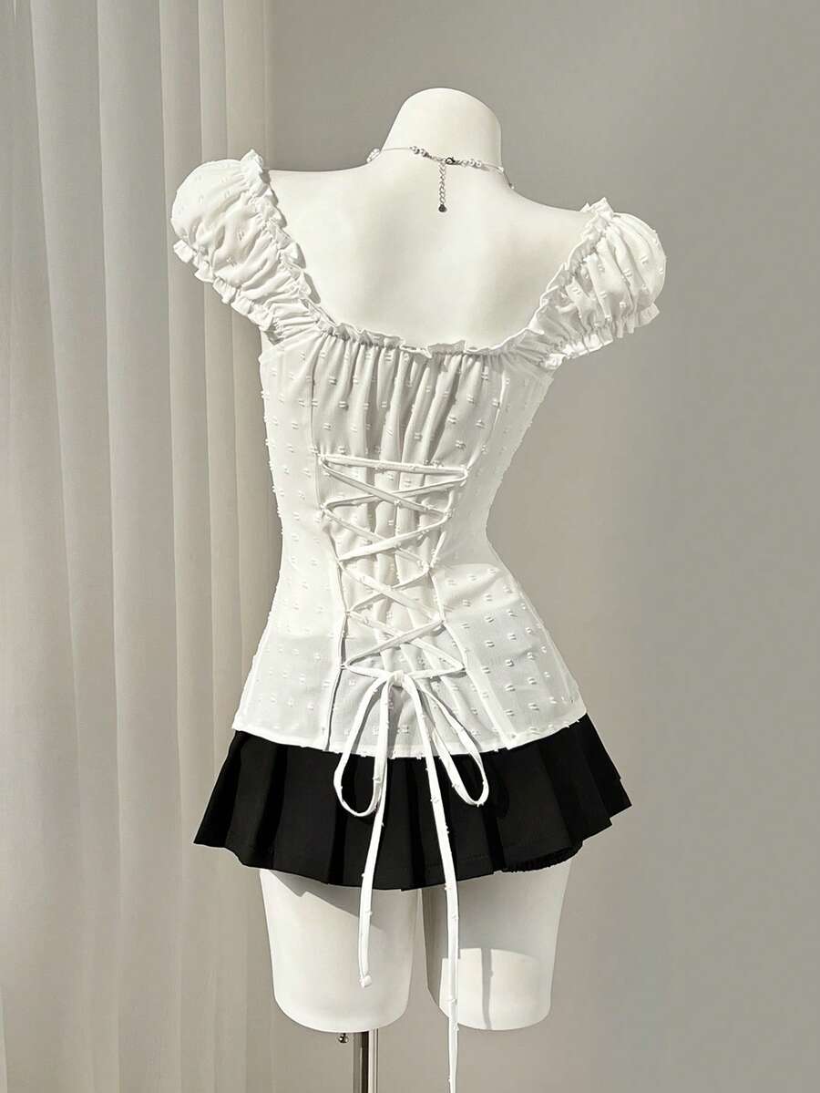 Women's black off-shoulder cap sleeve blouse with ruffled detailing and a tie-back design.
