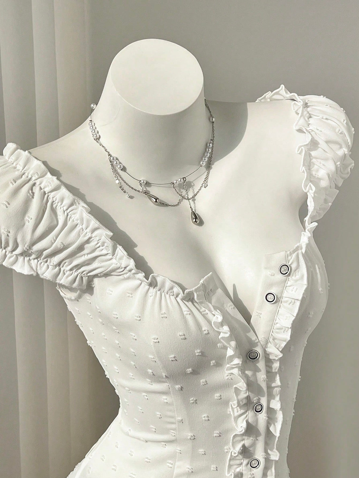 Women's black off-shoulder cap sleeve blouse with ruffled detailing and a tie-back design.