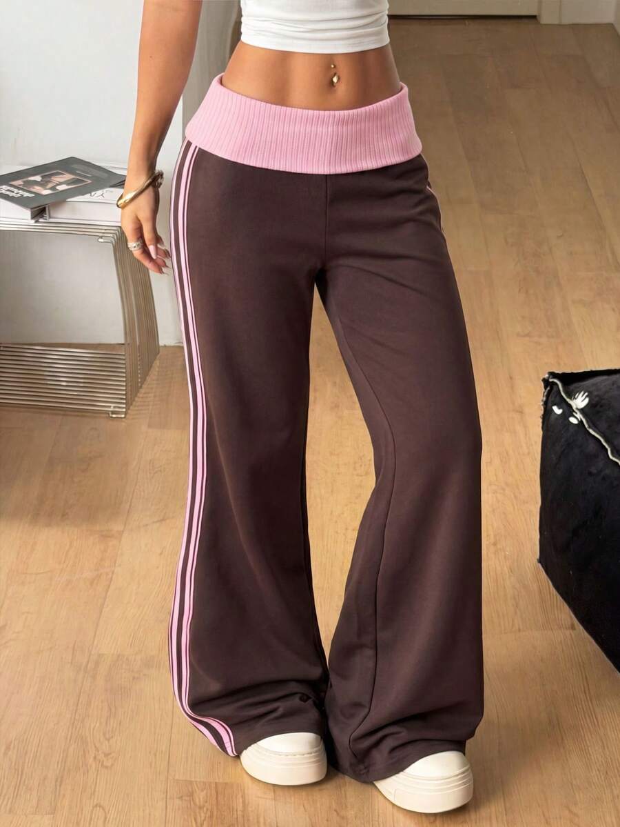 Women's wide leg flare sweatpants featuring a black and white colorblock contrast fold waistband and side stripe details.