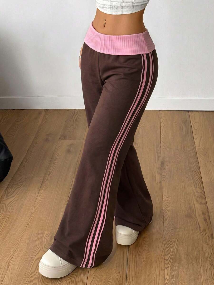 Women's wide leg flare sweatpants featuring a black and white colorblock contrast fold waistband and side stripe details.
