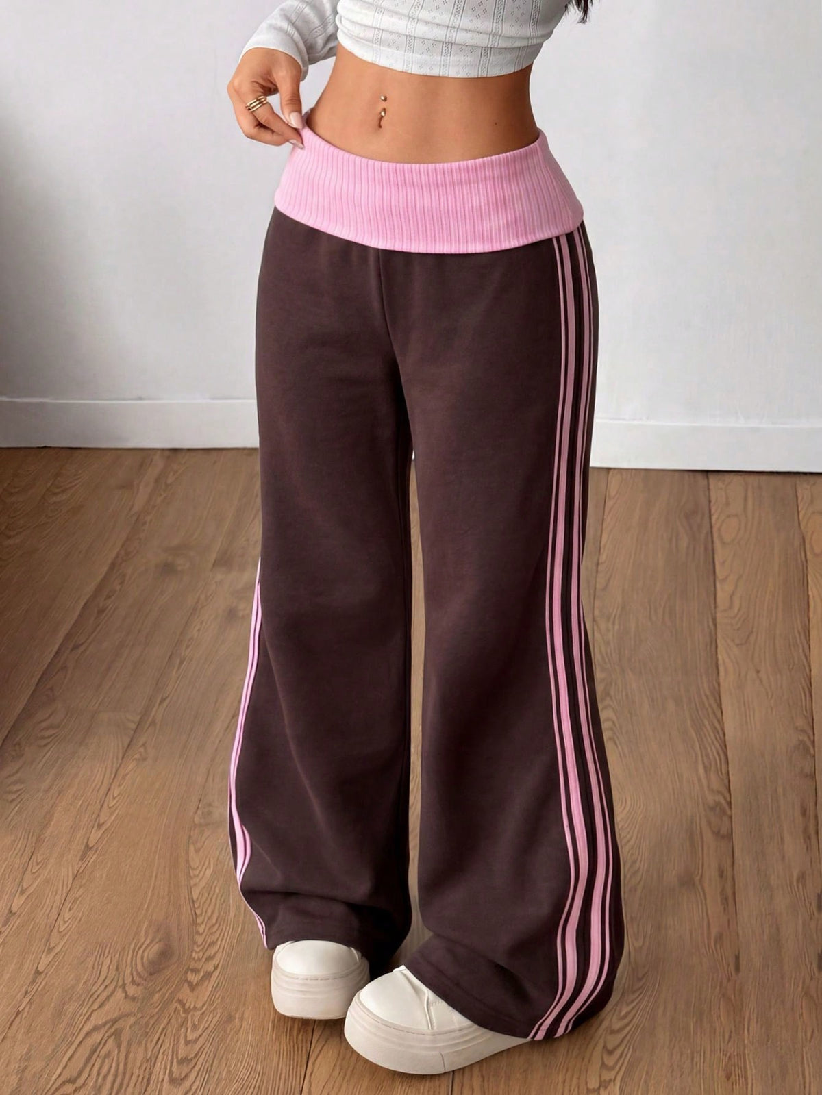 Women's wide leg flare sweatpants featuring a black and white colorblock contrast fold waistband and side stripe details.