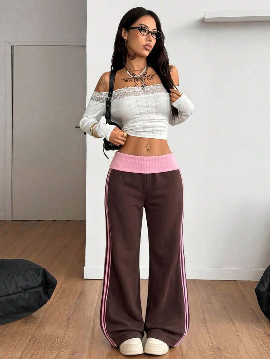Women's wide leg flare sweatpants featuring a black and white colorblock contrast fold waistband and side stripe details.