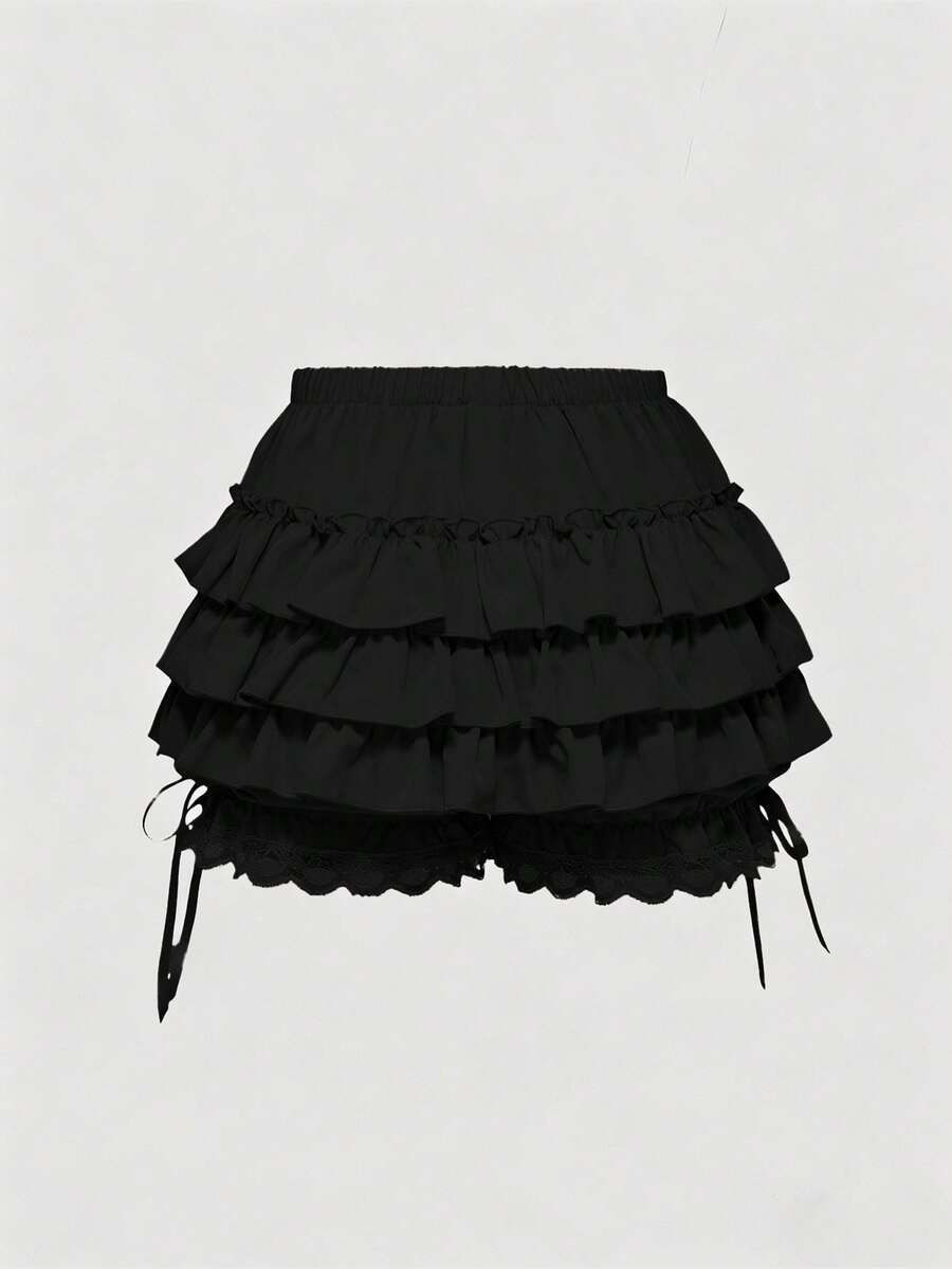 Women's tiered ruffle skort shorts featuring an elastic mid waist with front tie knot detail in woven fabric.