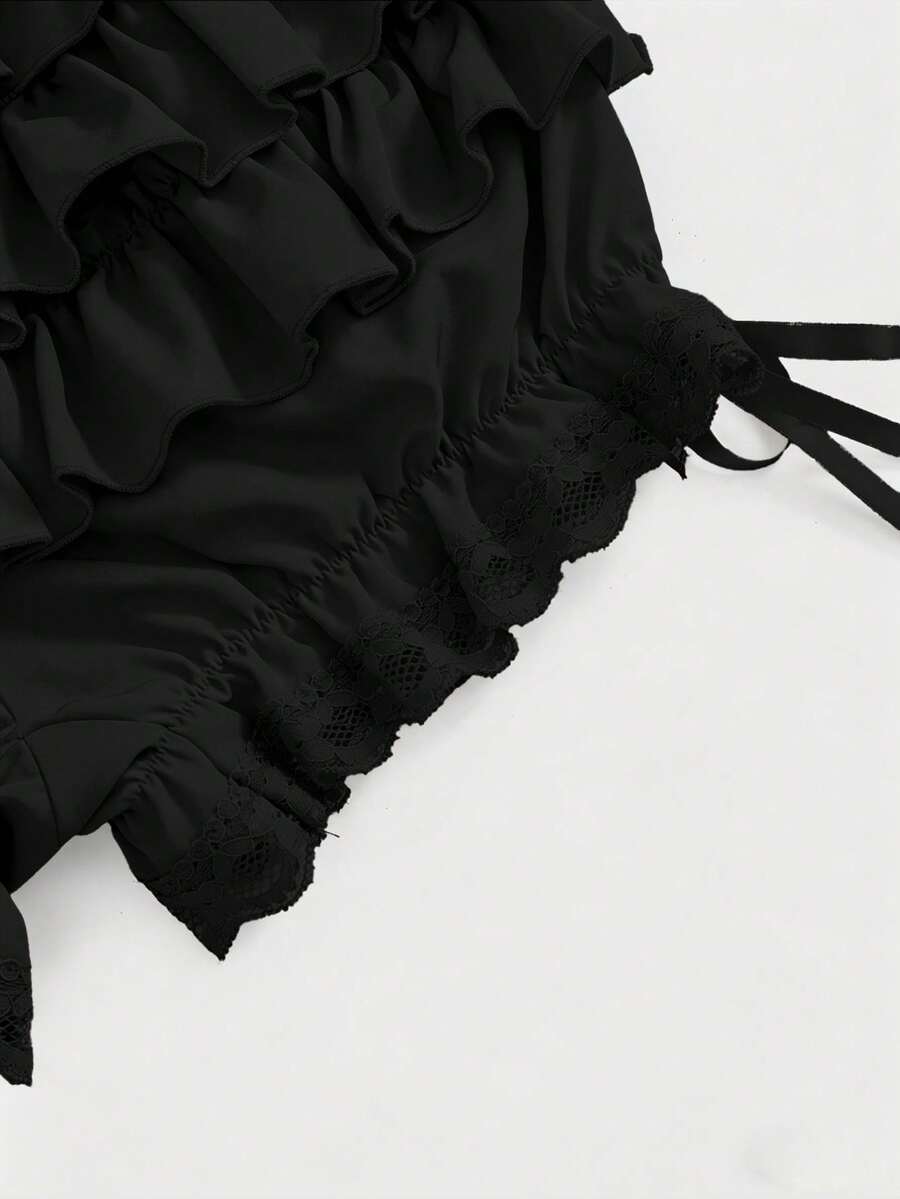 Women's tiered ruffle skort shorts featuring an elastic mid waist with front tie knot detail in woven fabric.