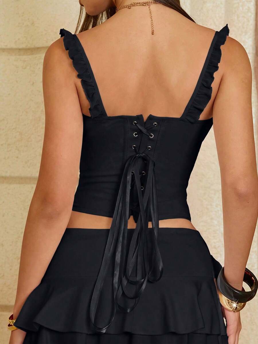 White cropped slim fit camisole top featuring ruffle lettuce trim, lace-up detail, and square neckline.