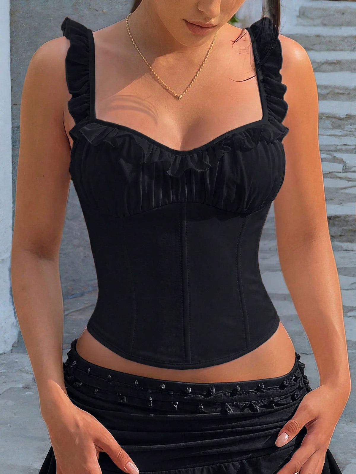 White cropped slim fit camisole top featuring ruffle lettuce trim, lace-up detail, and square neckline.