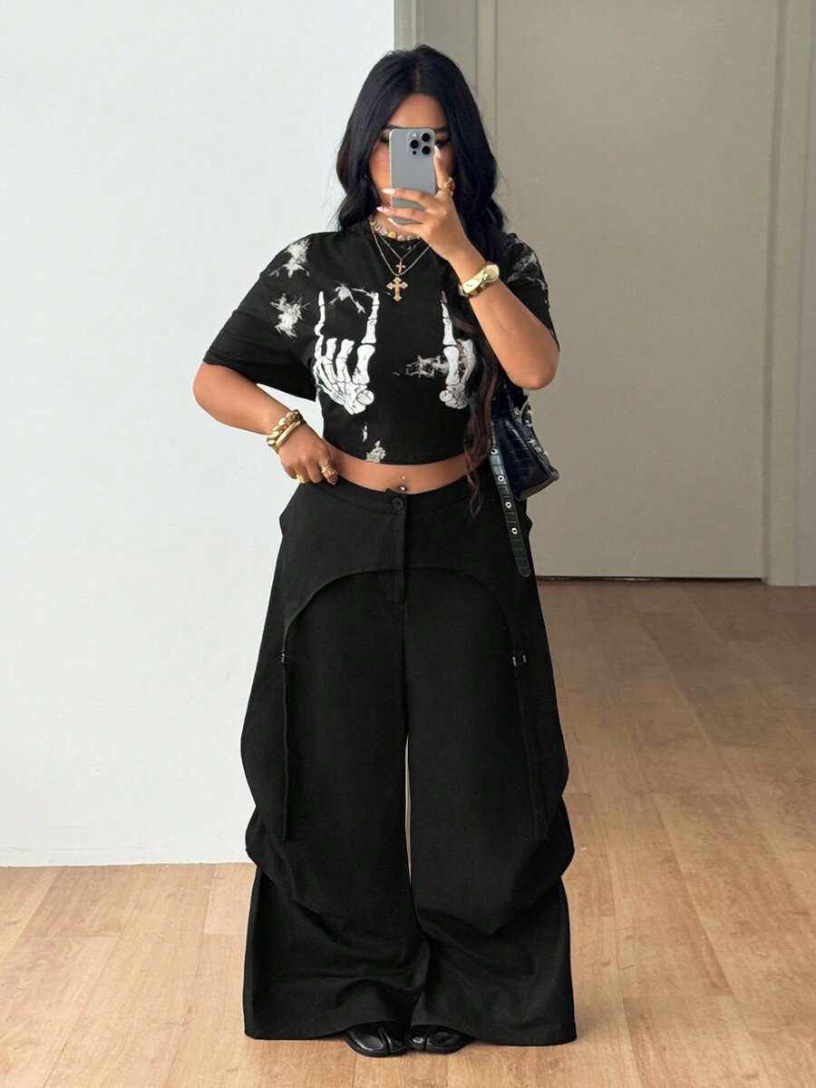 Women's plus size black wide leg parachute pants featuring an asymmetric high waist design in woven fabric.