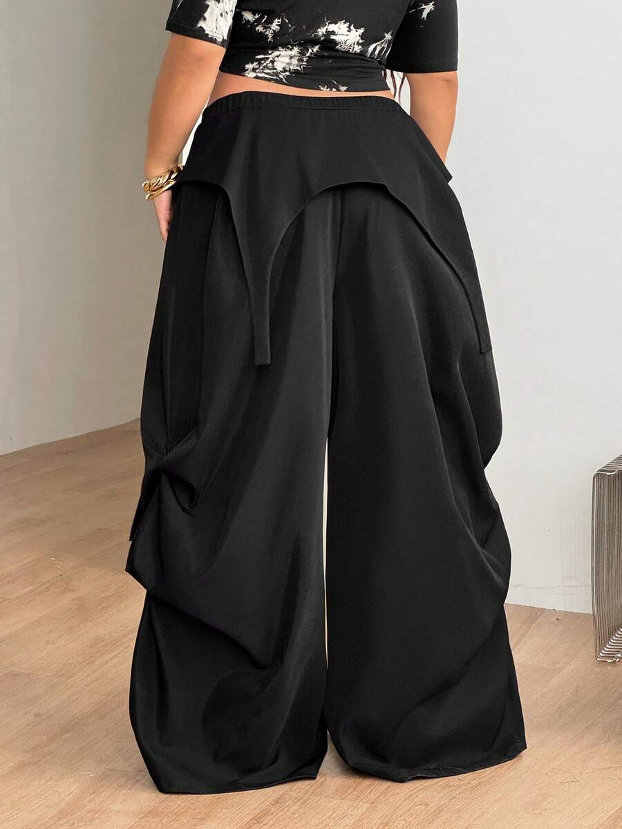 Women's plus size black wide leg parachute pants featuring an asymmetric high waist design in woven fabric.
