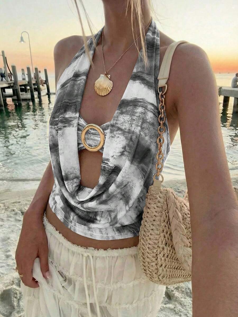 Brown and white polka dot semi-sheer halter camisole top with a plunging neckline, backless design, draped front, and metallic studded embellishments.