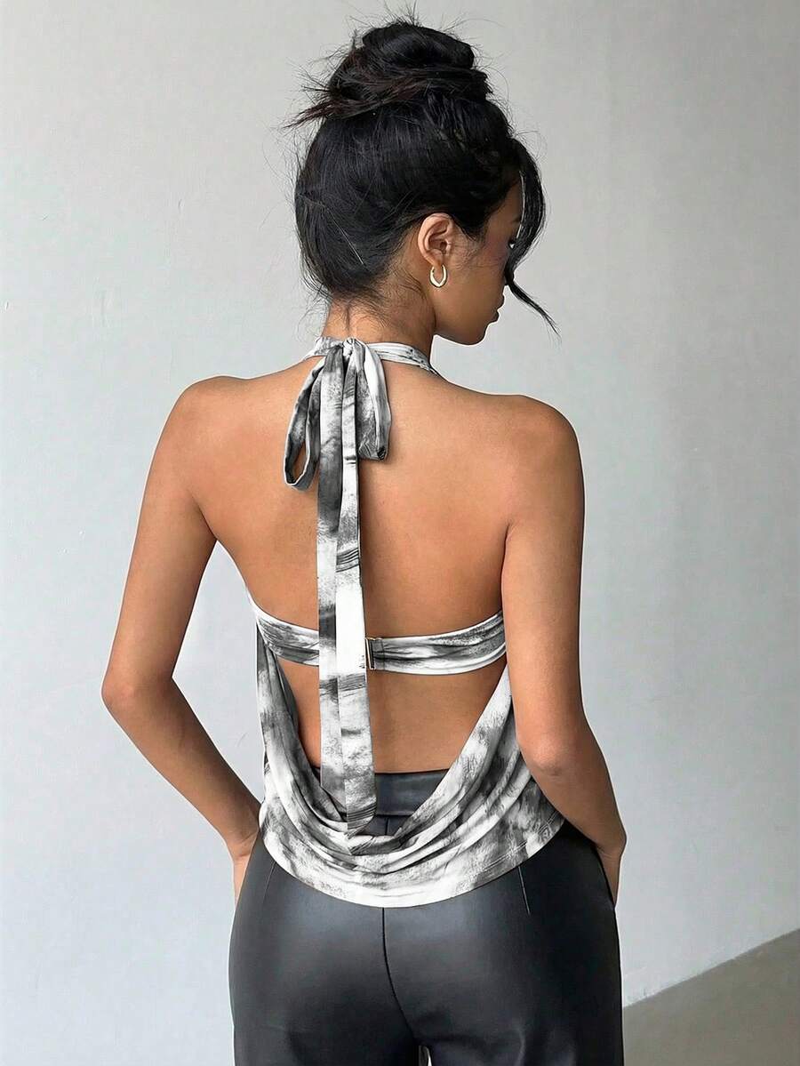 Brown and white polka dot semi-sheer halter camisole top with a plunging neckline, backless design, draped front, and metallic studded embellishments.