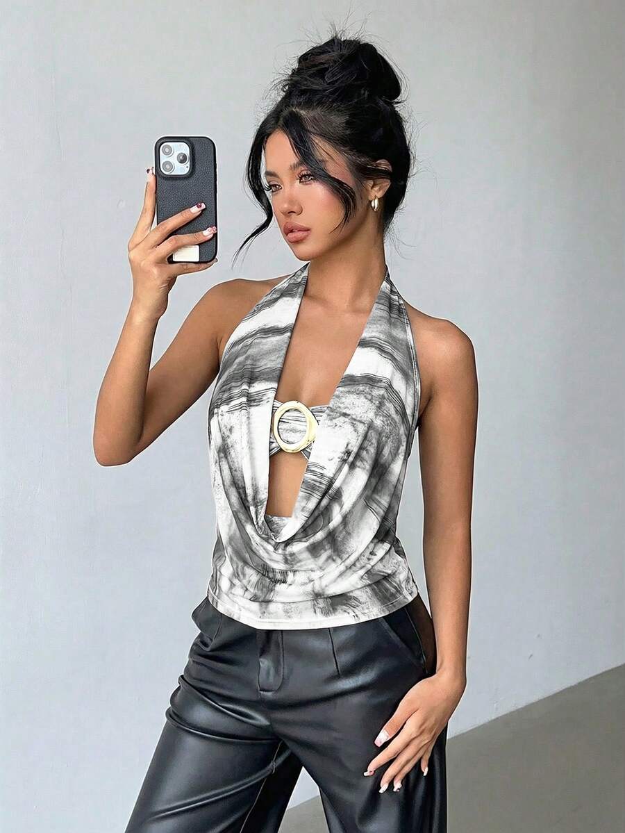 Brown and white polka dot semi-sheer halter camisole top with a plunging neckline, backless design, draped front, and metallic studded embellishments.