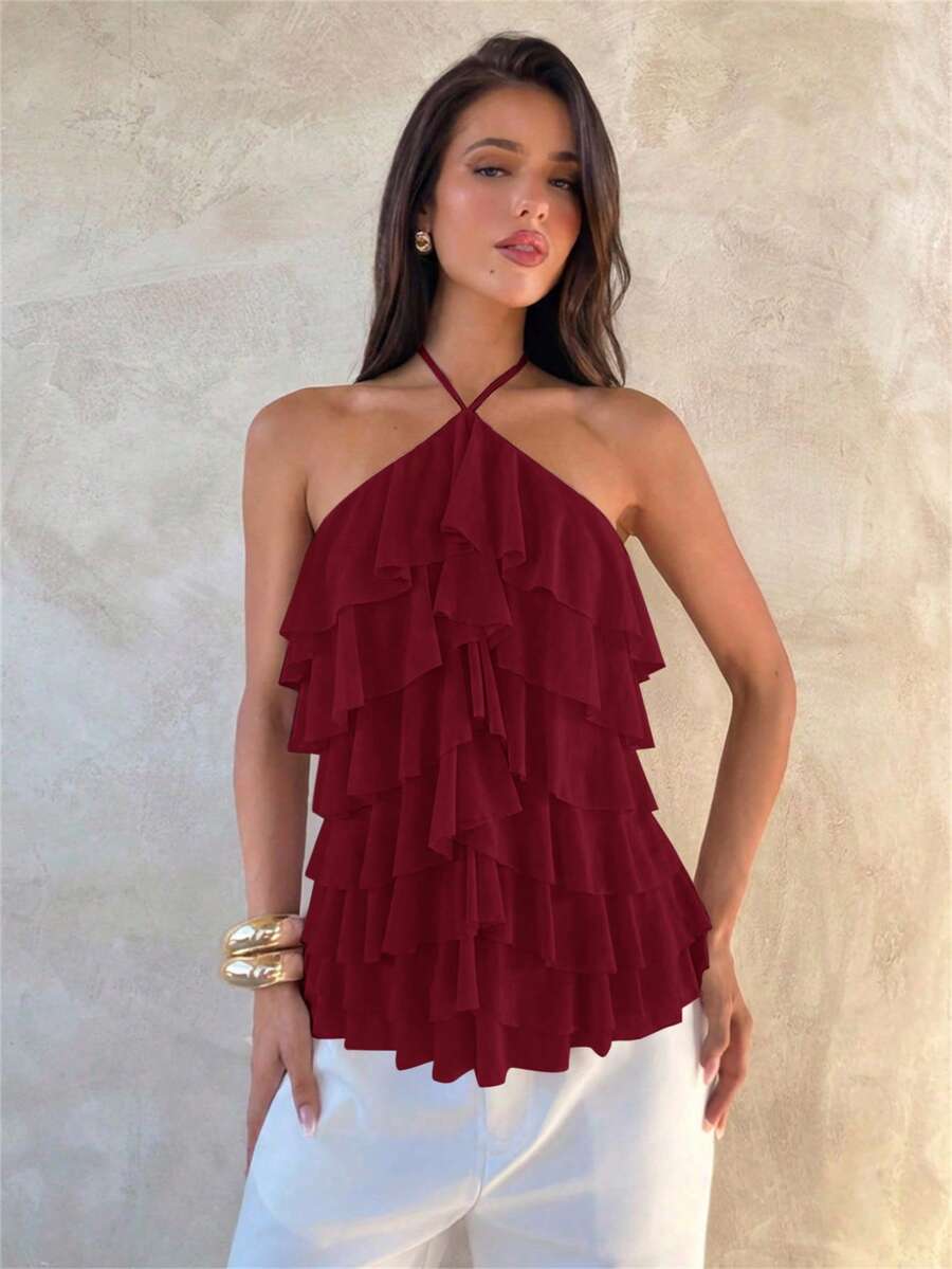 Women's sleeveless halter neck top featuring tiered ruffle layers, a backless cut, and an asymmetrical hem.