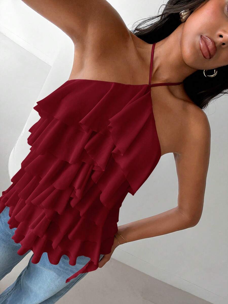 Women's sleeveless halter neck top featuring tiered ruffle layers, a backless cut, and an asymmetrical hem.