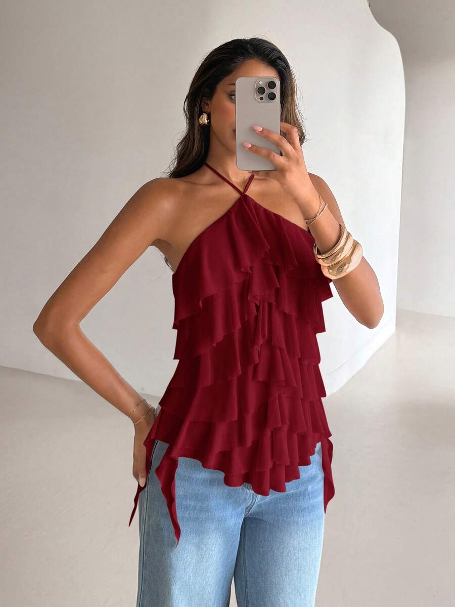 Women's sleeveless halter neck top featuring tiered ruffle layers, a backless cut, and an asymmetrical hem.