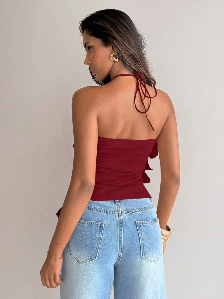 Women's sleeveless halter neck top featuring tiered ruffle layers, a backless cut, and an asymmetrical hem.