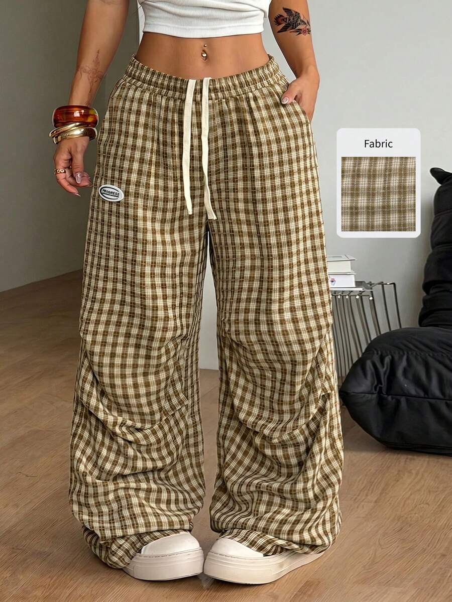 Women's black and white striped wide leg pants featuring an elastic drawstring waistband, side pockets, and a loose straight leg fit.