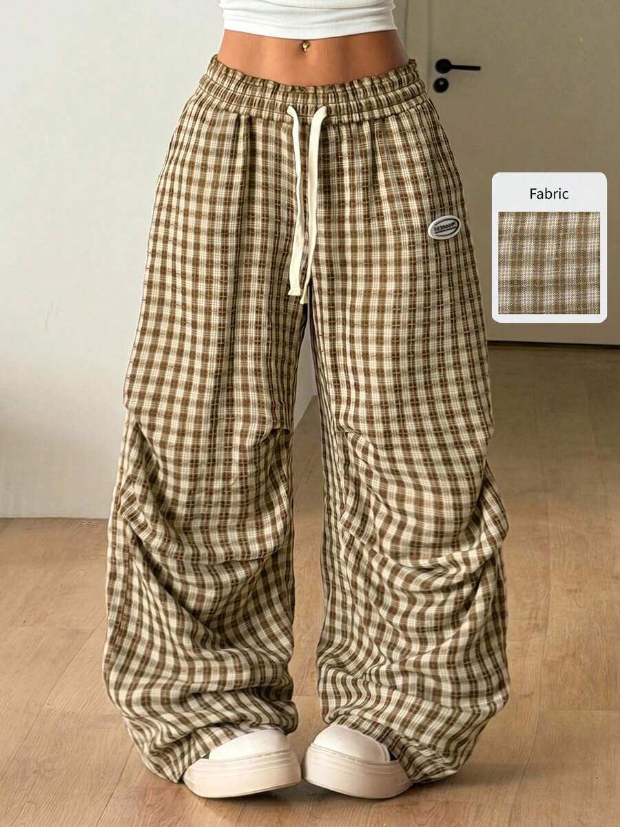 Women's black and white striped wide leg pants featuring an elastic drawstring waistband, side pockets, and a loose straight leg fit.