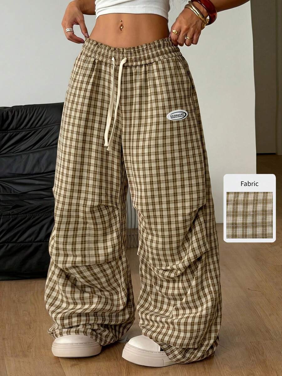 Women's black and white striped wide leg pants featuring an elastic drawstring waistband, side pockets, and a loose straight leg fit.
