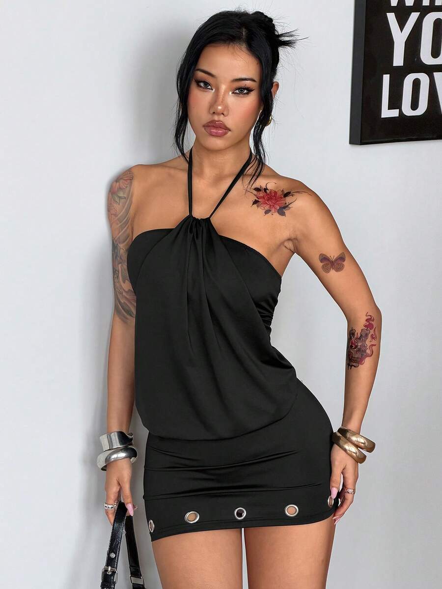 Front view of women's black halter neck mini dress featuring grommet eyelet details, a sleeveless cut, and slim fit silhouette in stretchy knitted fabric.