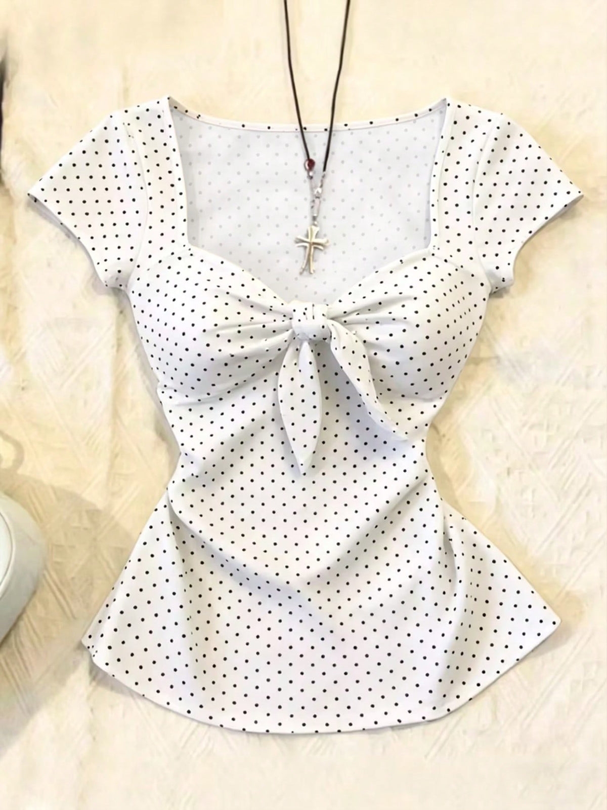 Women's polka dot short sleeve raglan t-shirt with a twist front detail and contrast collar.