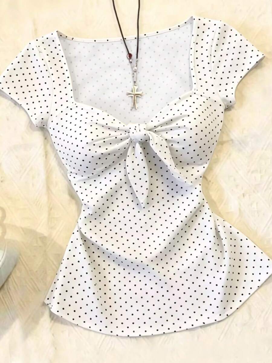Women's polka dot short sleeve raglan t-shirt with a twist front detail and contrast collar.