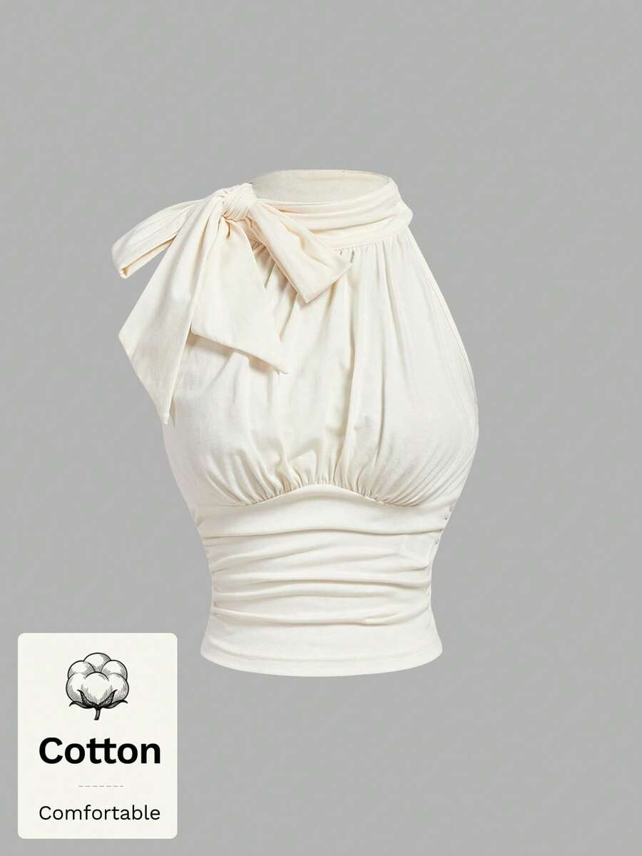 Women's sleeveless high-neck halter crop top in apricot with ruched knot front detailing.