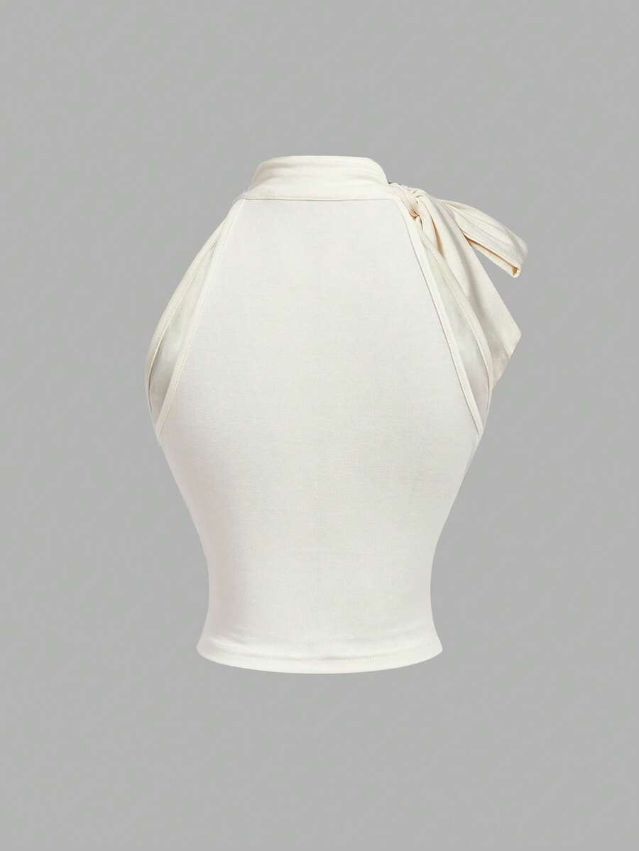 Women's sleeveless high-neck halter crop top in apricot with ruched knot front detailing.