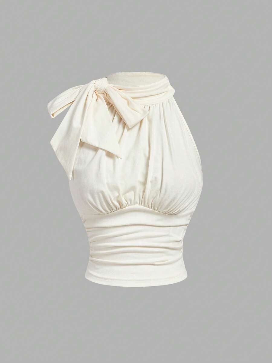 Women's sleeveless high-neck halter crop top in apricot with ruched knot front detailing.