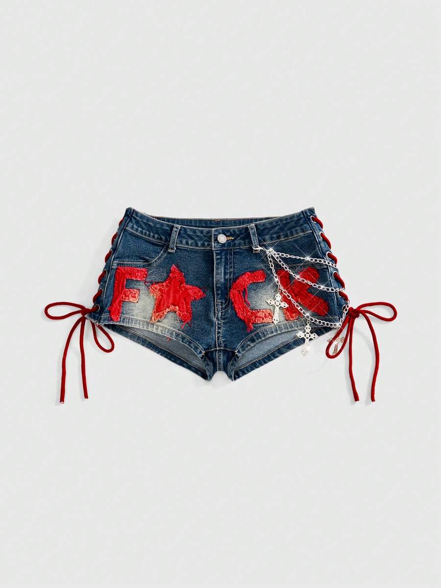 Women's Y2K low waist camo mini skort shorts featuring lace-up knot details, grommet eyelets, graphic lettering pattern, and a zipper fly.