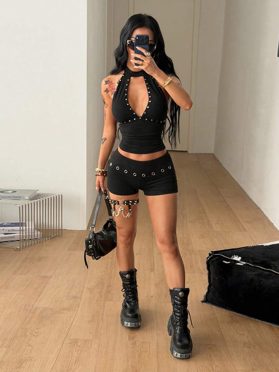 Women's black ultra low rise mini shorts with grommet eyelet and rib-knit details, zipper fly closure, skinny straight-leg fit, and plain knitted fabric.
