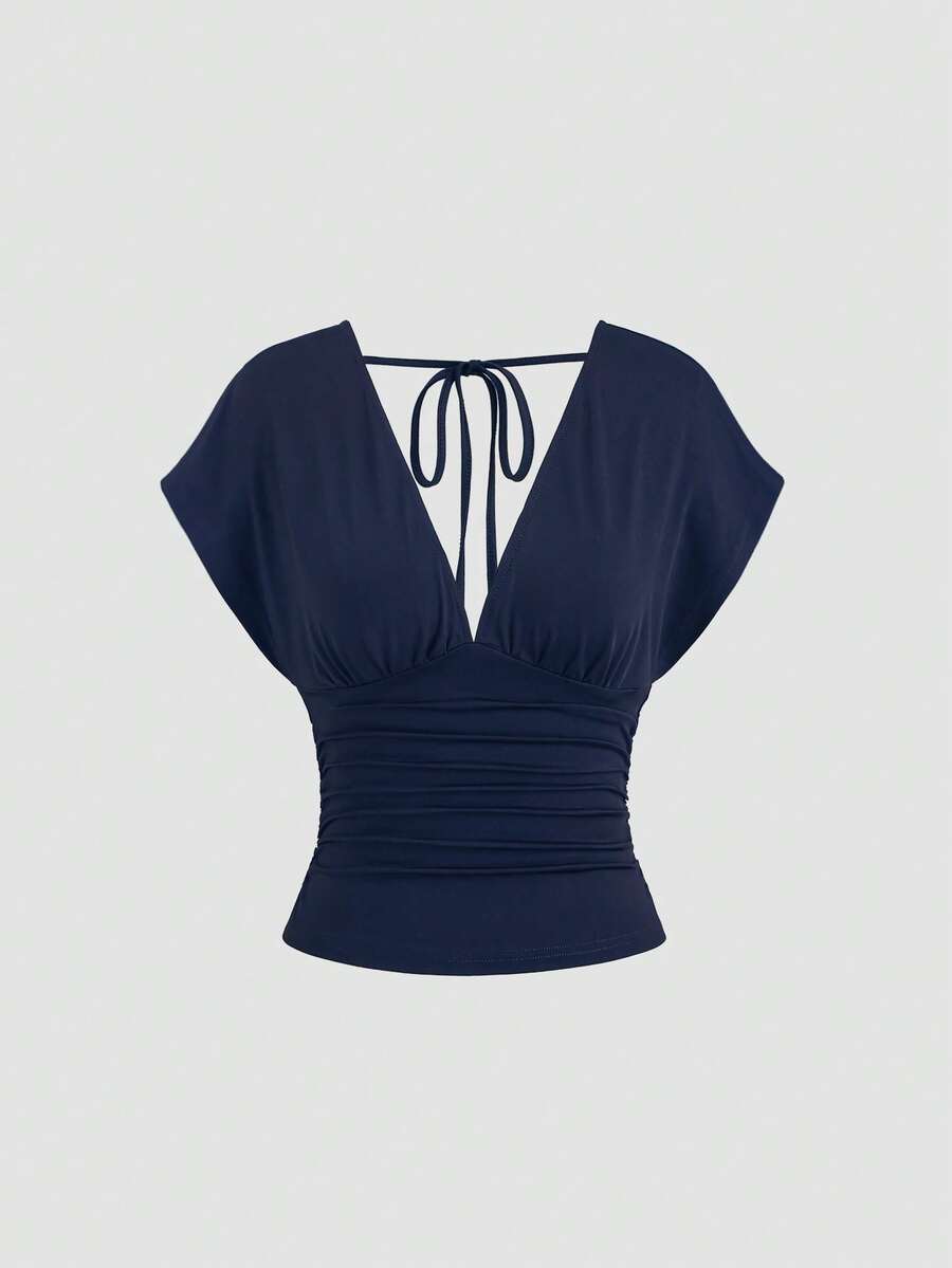 Women's black knitted t-shirt featuring a reversible deep v-neckline, batwing cap sleeves, ruched detailing, and a slim fit waist.