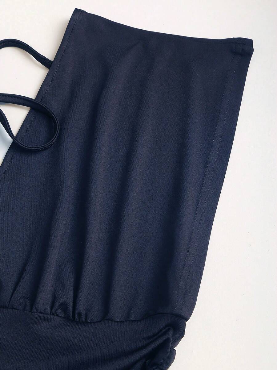 Women's black knitted t-shirt featuring a reversible deep v-neckline, batwing cap sleeves, ruched detailing, and a slim fit waist.