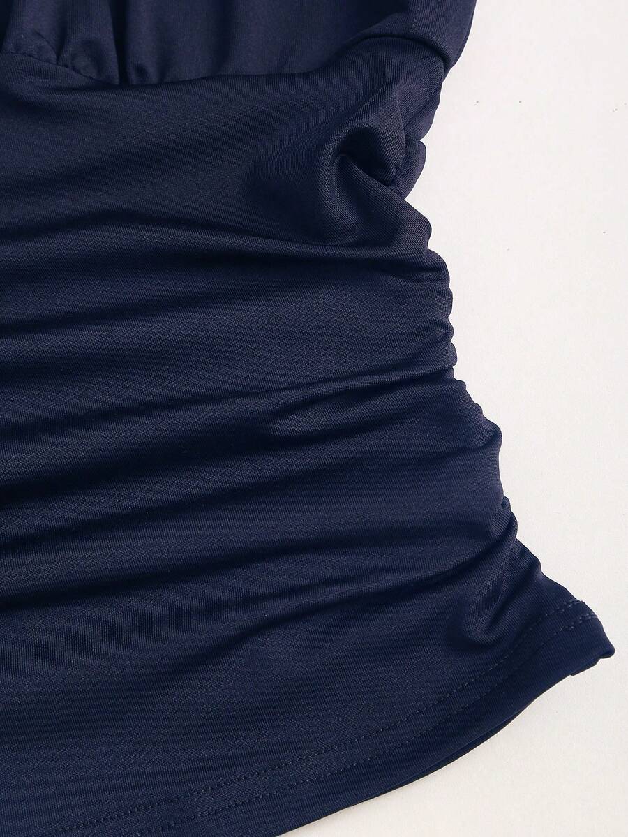 Women's black knitted t-shirt featuring a reversible deep v-neckline, batwing cap sleeves, ruched detailing, and a slim fit waist.