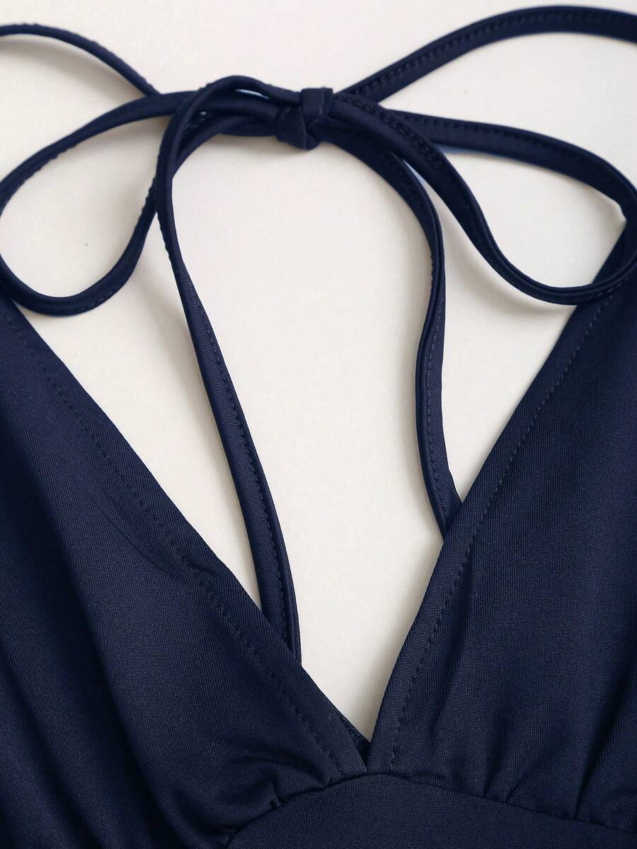 Women's black knitted t-shirt featuring a reversible deep v-neckline, batwing cap sleeves, ruched detailing, and a slim fit waist.