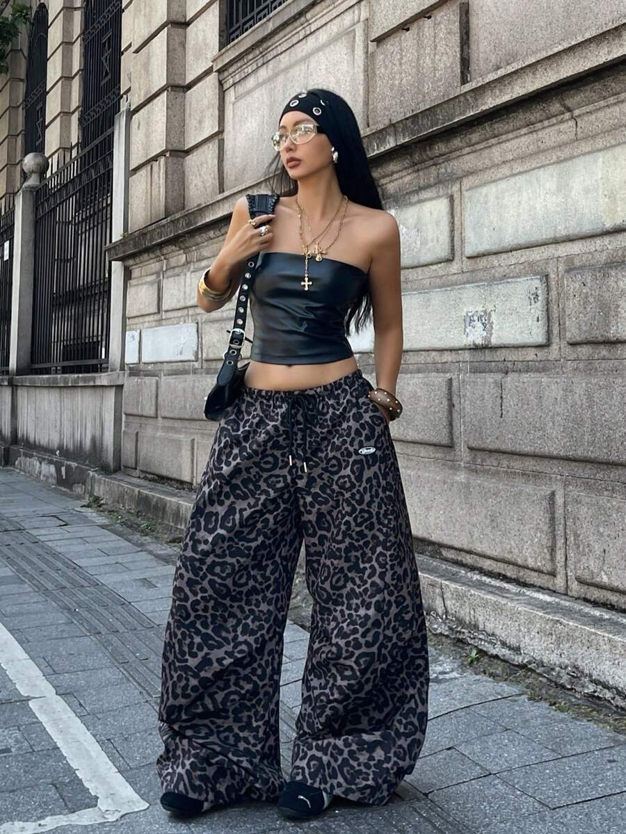 Women's black baggy jogger pants with an adjustable drawstring waist and colorblock polka dot geometric pattern.