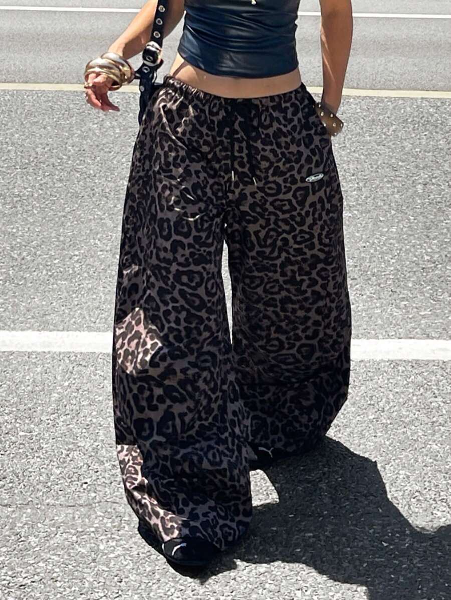 Women's black baggy jogger pants with an adjustable drawstring waist and colorblock polka dot geometric pattern.