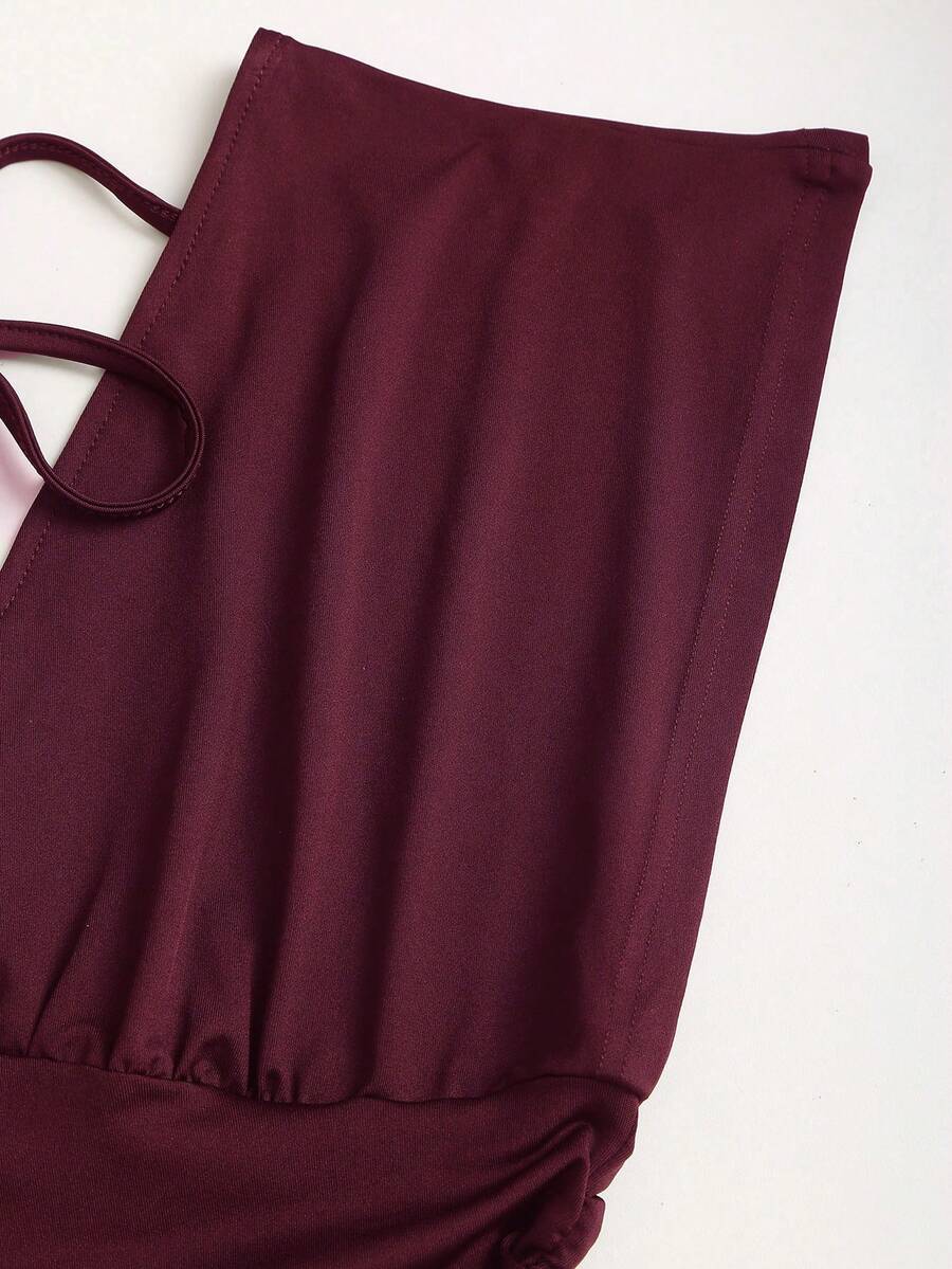Women's black knitted t-shirt featuring a reversible deep v-neckline, batwing cap sleeves, ruched detailing, and a slim fit waist.