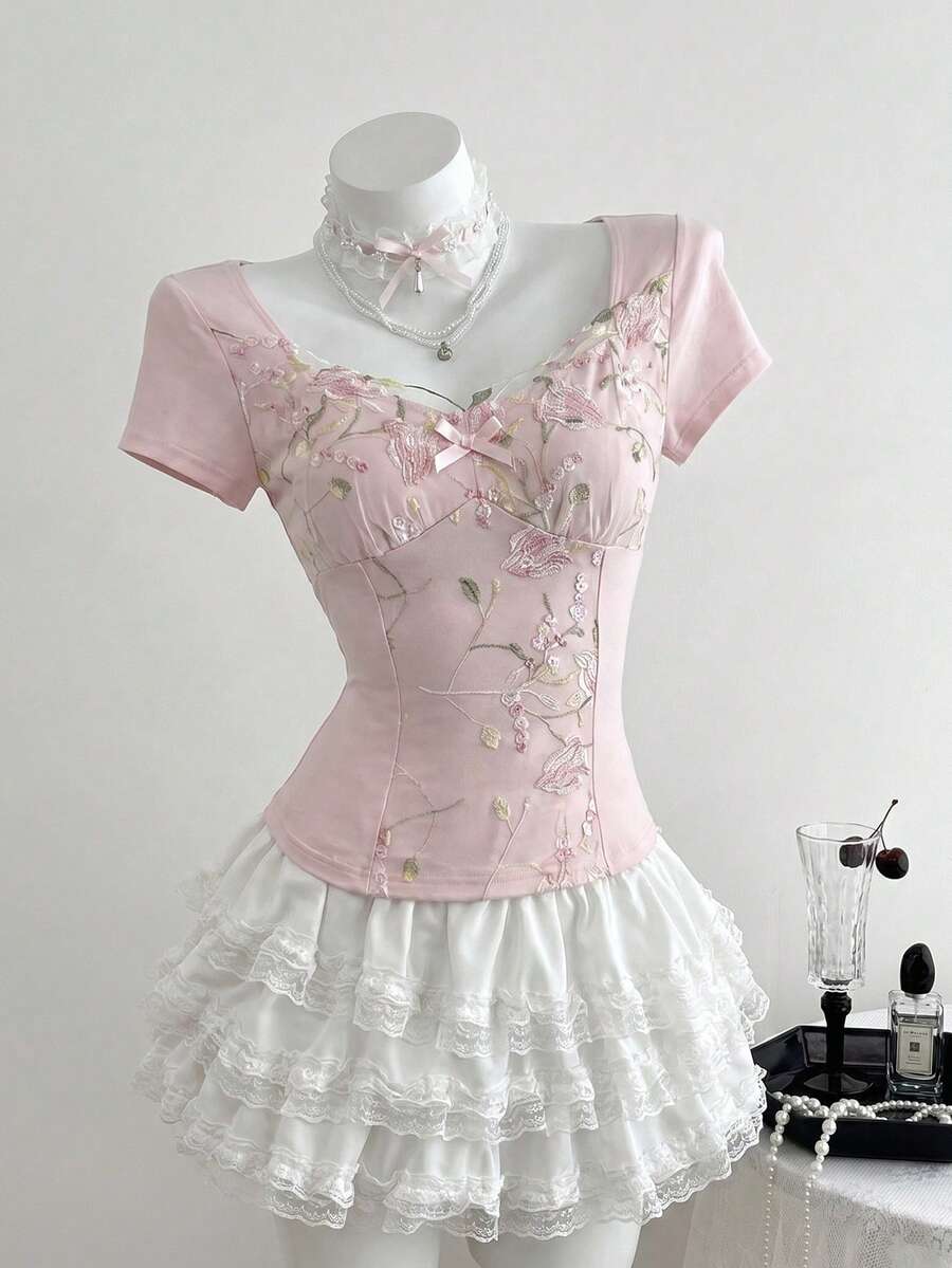 Women's pink short sleeve slim fit dress featuring a plant pattern, scoop neck, ruched appliques, and button front detail.