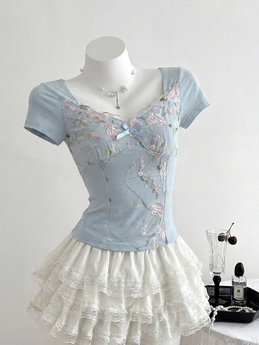 Women's pink short sleeve slim fit dress featuring a plant pattern, scoop neck, ruched appliques, and button front detail.