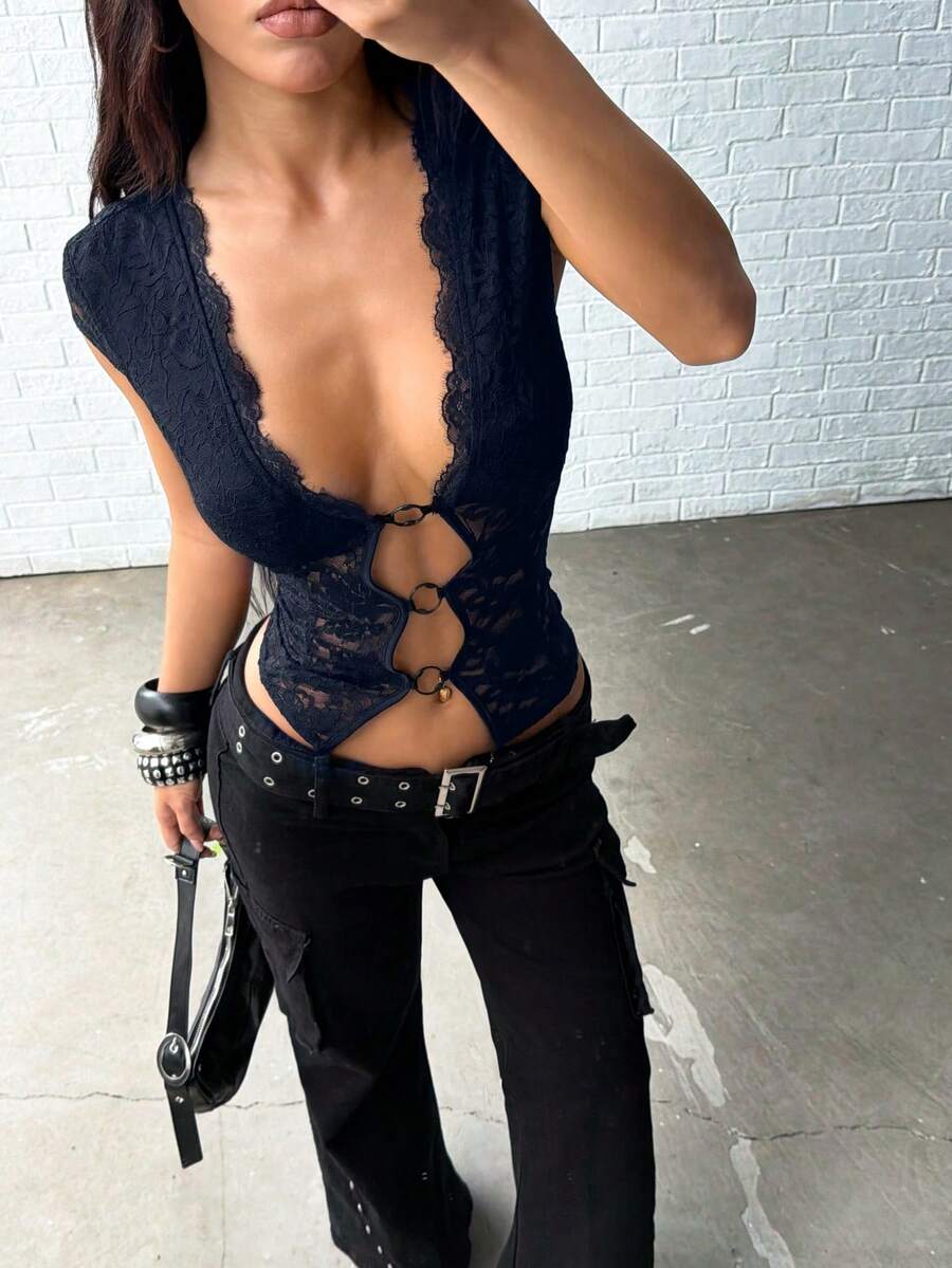 Women's black slim fit semi-sheer blouse featuring contrast lace detailing, a deep V hollow design with ring accent, asymmetrical hem, and cap sleeves.