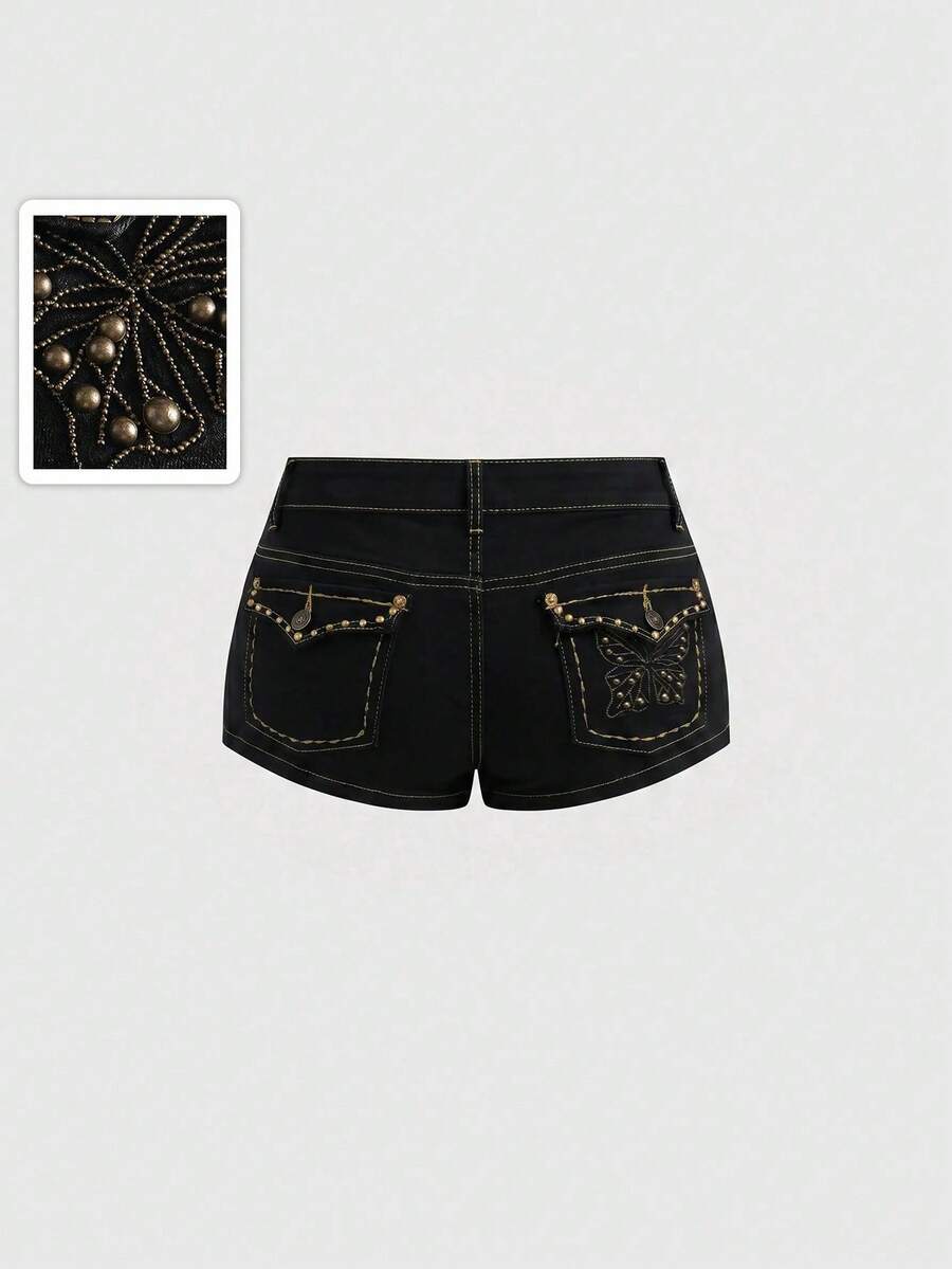 Women's Y2K low waist distressed shorts featuring butterfly studded details, pockets, and a zipper fly closure.