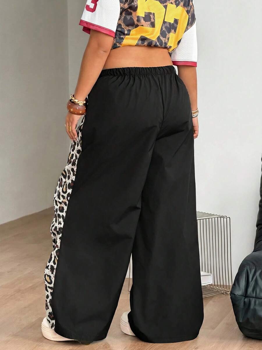 Women's high waist wide leg pants in black featuring leopard print patchwork details and an elastic drawstring waistband.
