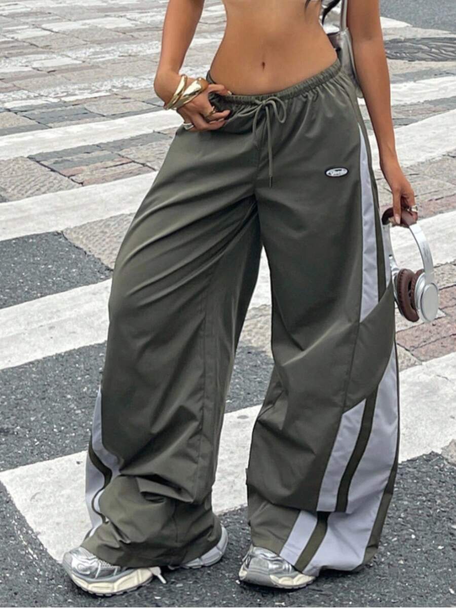 Women's plus size loose straight leg pants featuring a black and white color block design with side stripes and an elastic drawstring waist.