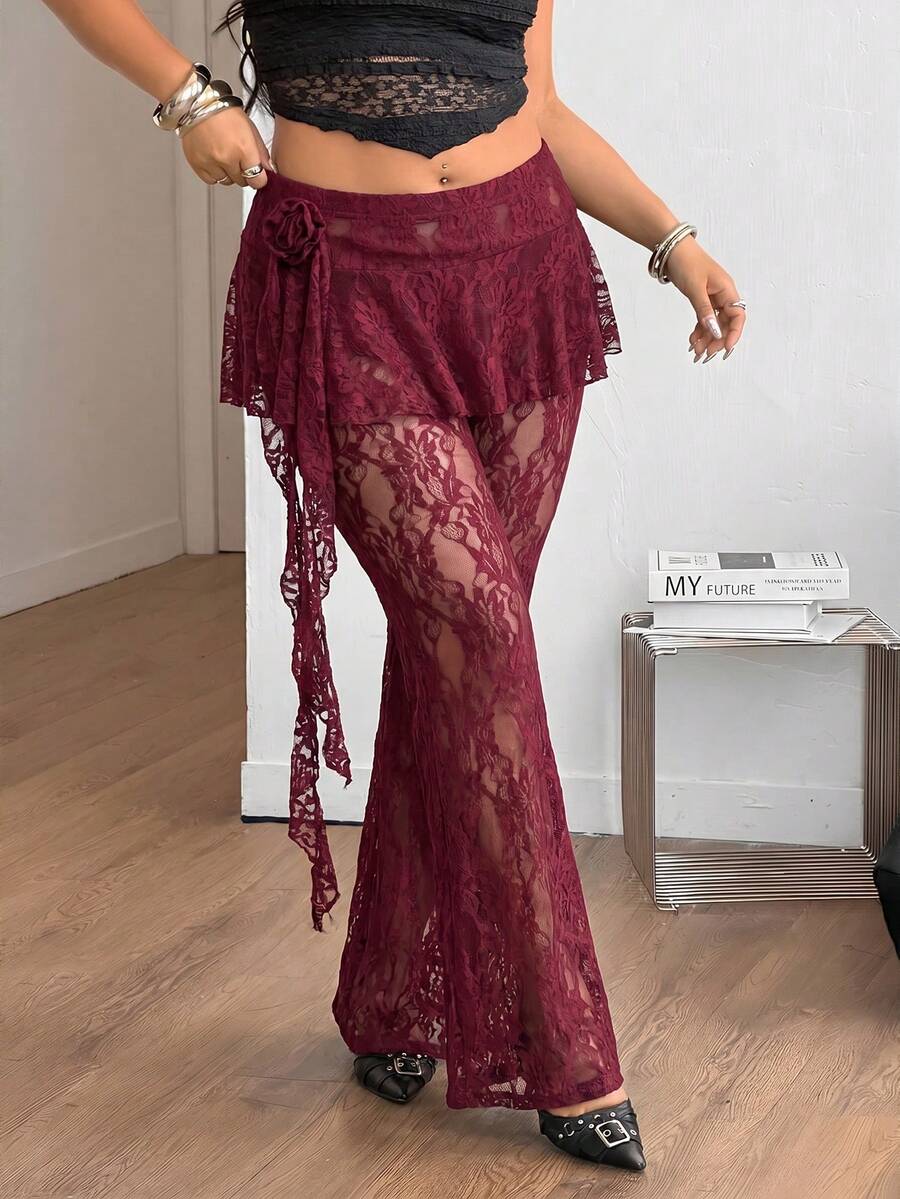 Black high-waist flare leg pants featuring contrast lace trim, floral ribbon detail, and semi-sheer knitted fabric.