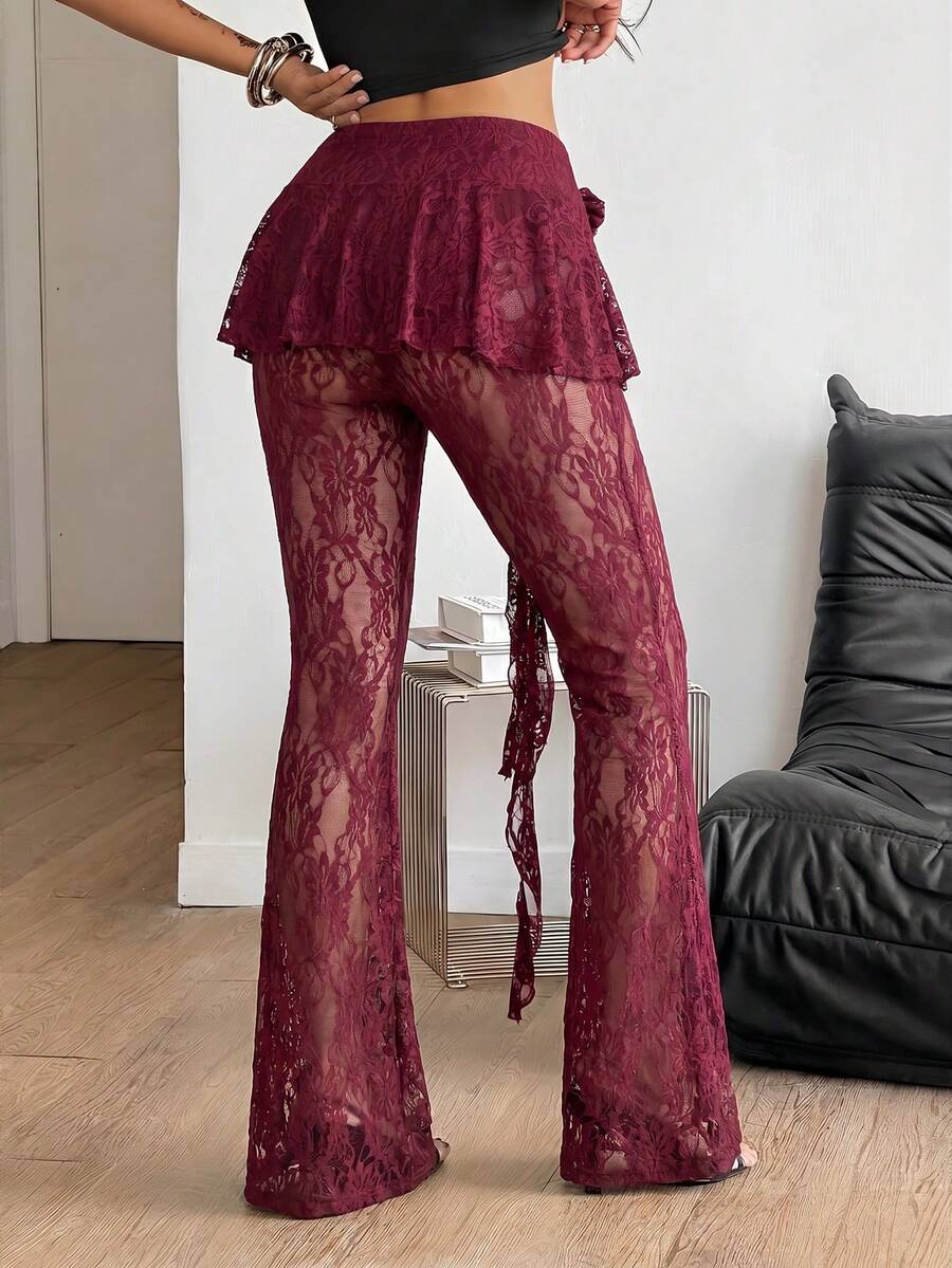 Black high-waist flare leg pants featuring contrast lace trim, floral ribbon detail, and semi-sheer knitted fabric.