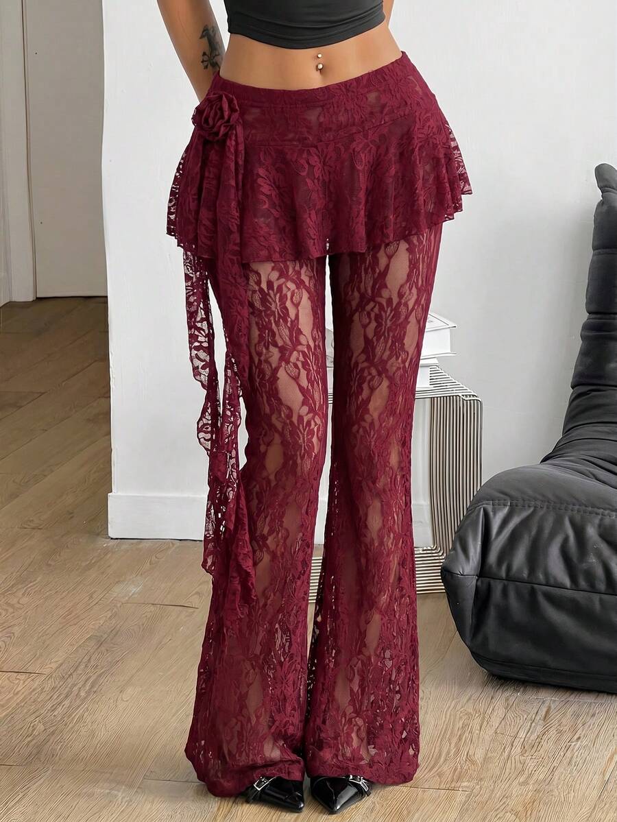 Black high-waist flare leg pants featuring contrast lace trim, floral ribbon detail, and semi-sheer knitted fabric.