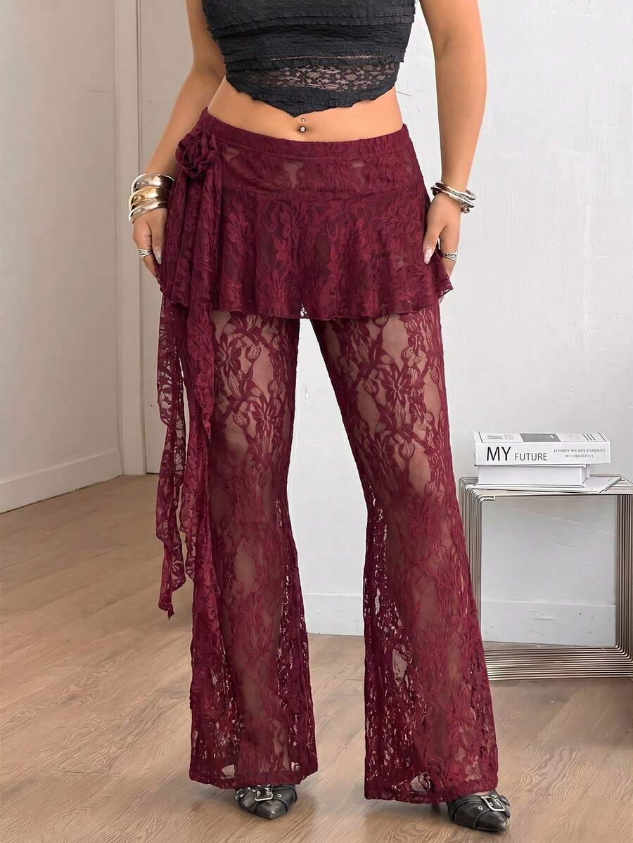 Black high-waist flare leg pants featuring contrast lace trim, floral ribbon detail, and semi-sheer knitted fabric.
