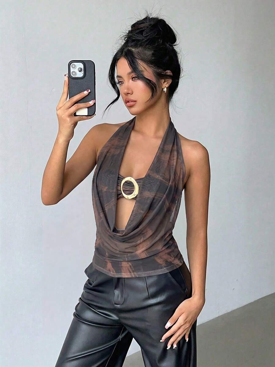 Brown and white polka dot semi-sheer halter camisole top with a plunging neckline, backless design, draped front, and metallic studded embellishments.